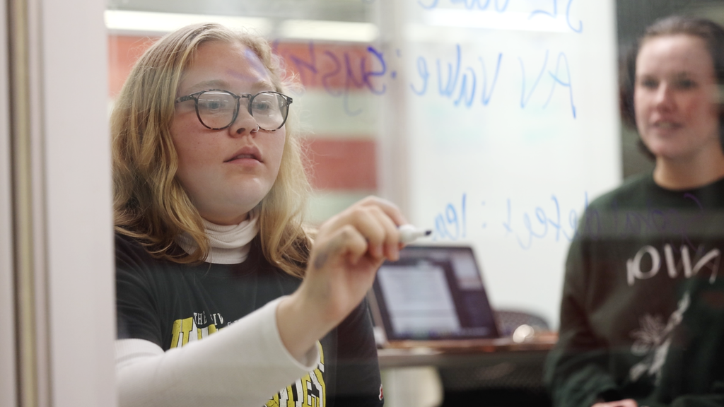 looking at student writing equations on glass