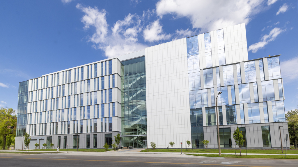 A wide shot of the Health Sciences Academic building against a blue sky. 